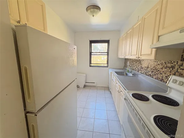 a kitchen with a refrigerator a stove and a sink