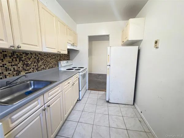 a kitchen with a sink a refrigerator and cabinets