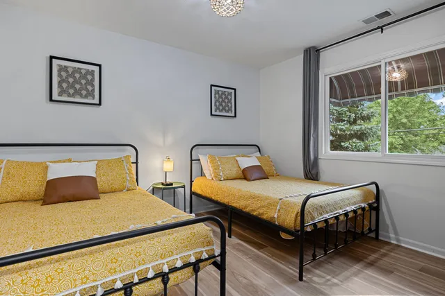 a bedroom with two beds and window