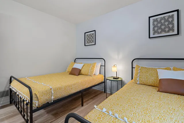 a bedroom with two beds and painting on the wall