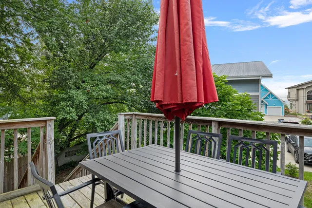 a view of a deck with a table and chairs a barbeque with wooden floor and fence
