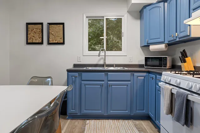 a kitchen with granite countertop a sink a stove and cabinets
