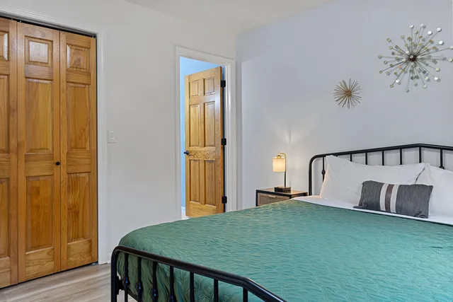 a bedroom with a bed and wooden floor