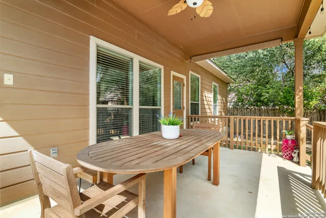 a view of a deck with wooden floor and fence with a table