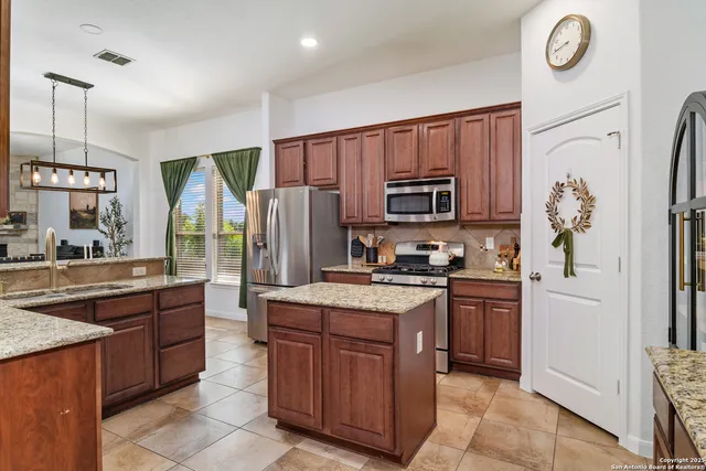 a kitchen with stainless steel appliances granite countertop a stove refrigerator sink and microwave