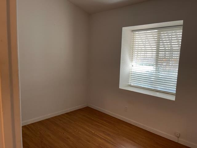 166 Oak Tree Circle Murphys, CA 95247 - Photo 12 of 21 a view of an empty room with wooden floor and a window