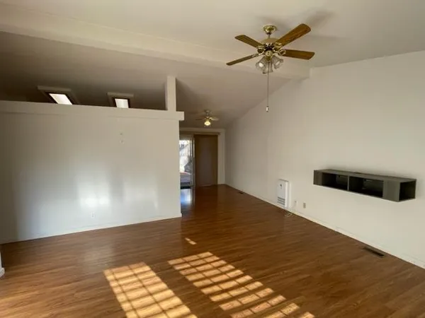 a view of a livingroom with a ceiling fan and wooden floor