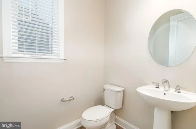 a bathroom with a toilet a sink and mirror