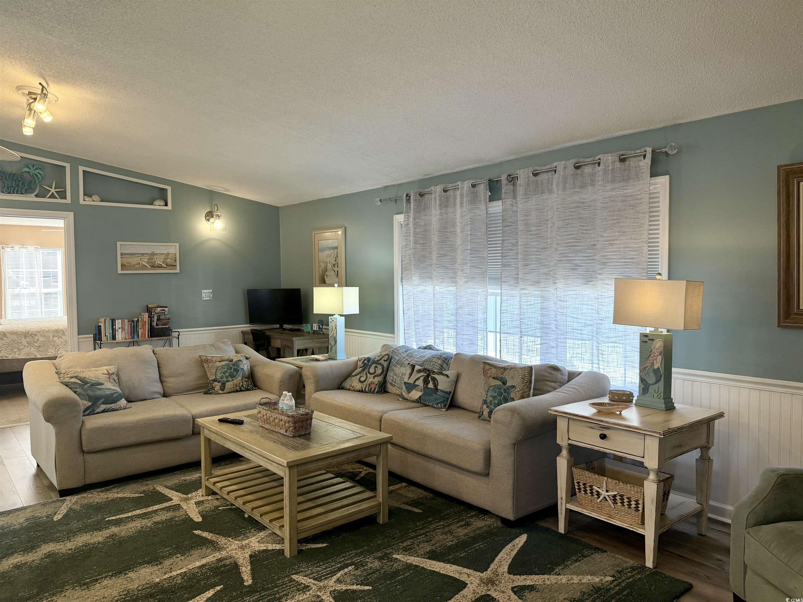 427 Meadowlark Surfside Beach, SC 29575 - Photo 22 of 33 Living room featuring a textured ceiling, a wainscoted wall, vaulted ceiling, and wood finished floors