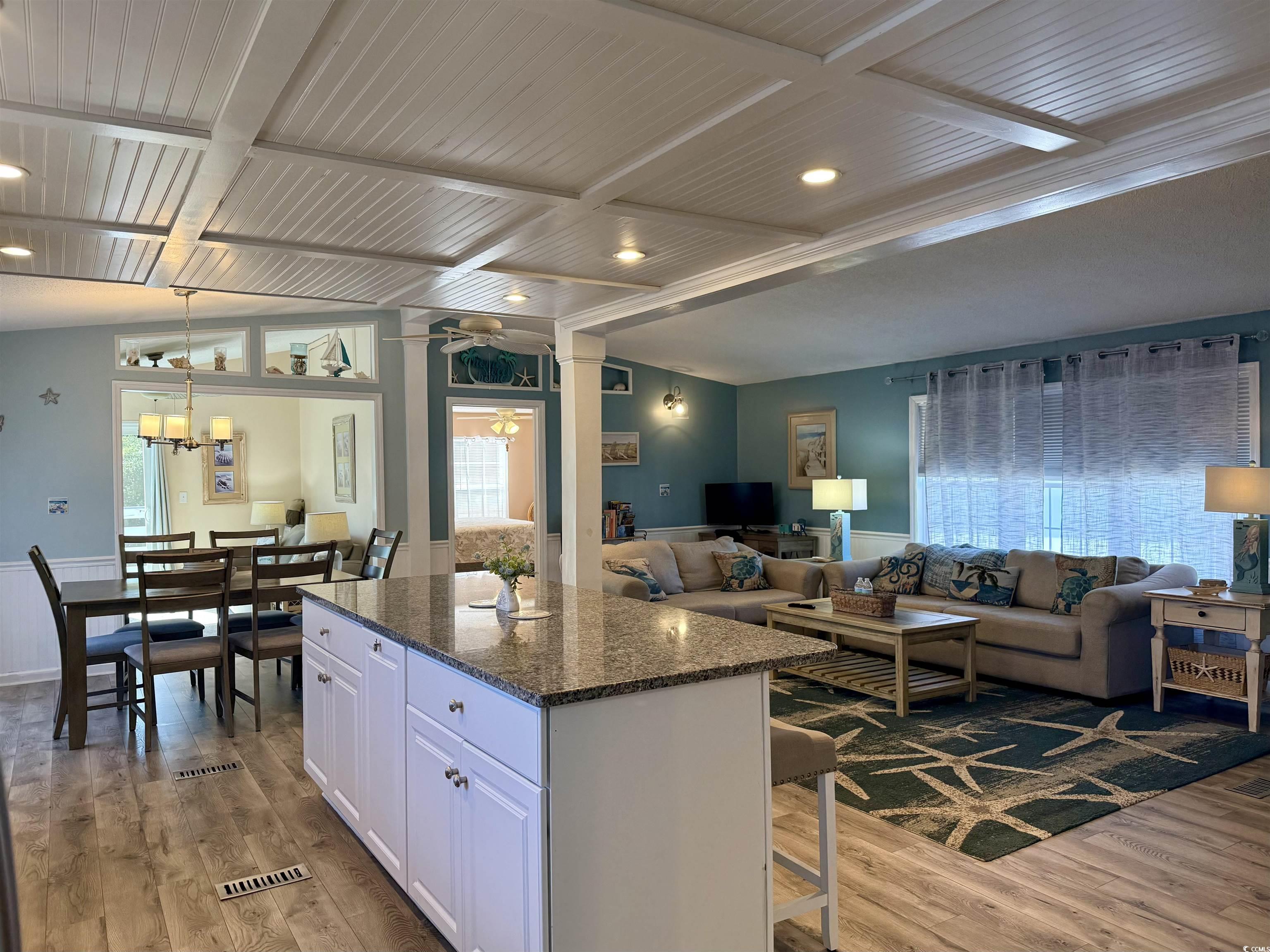 427 Meadowlark Surfside Beach, SC 29575 - Photo 33 of 33 Kitchen with open floor plan, dark stone countertops, a kitchen bar, decorative light fixtures, and white cabinetry