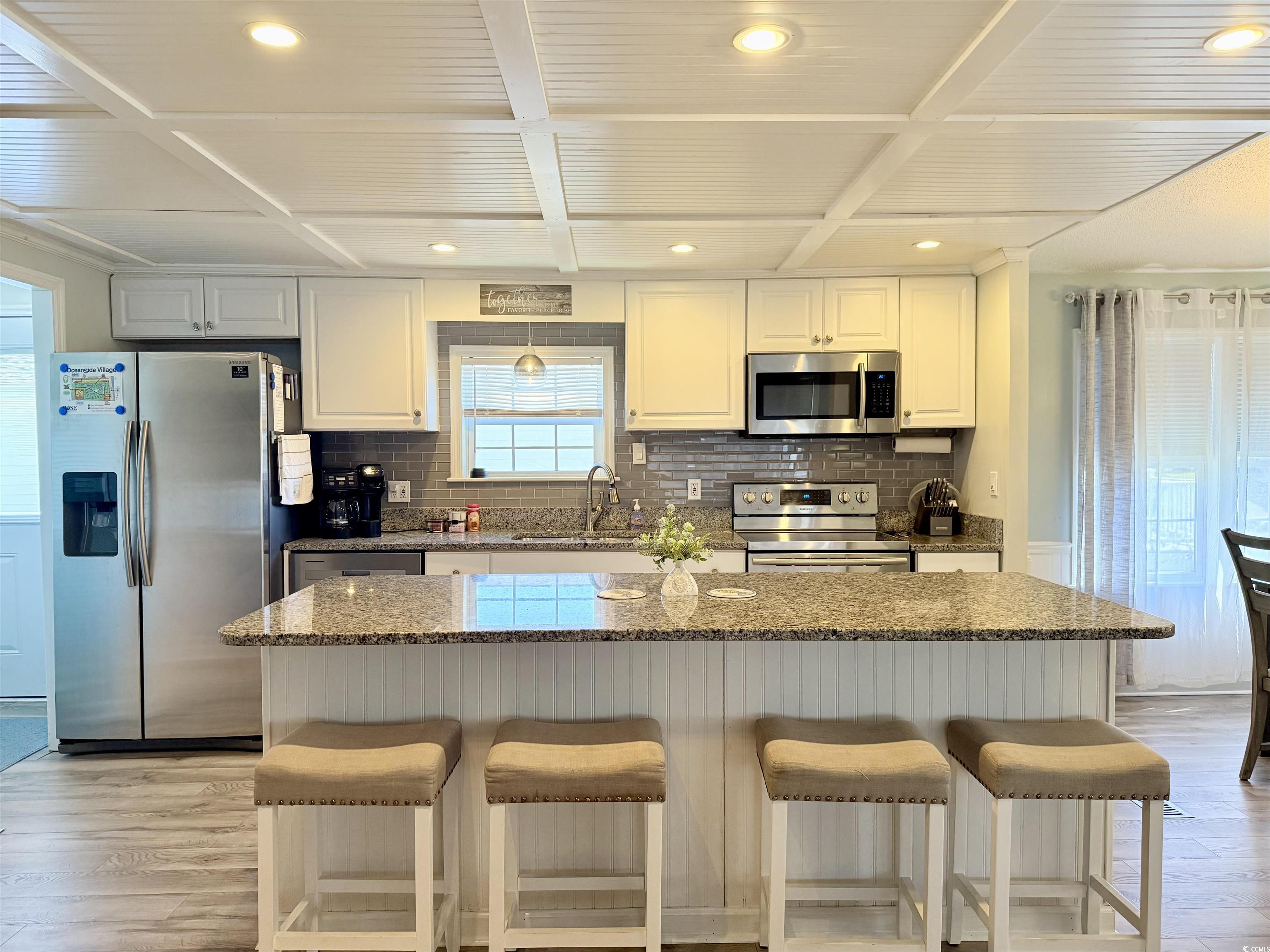 427 Meadowlark Surfside Beach, SC 29575 - Photo 3 of 33 Kitchen featuring recessed lighting, light wood-style flooring, stainless steel appliances, dark stone counters, and a breakfast bar area