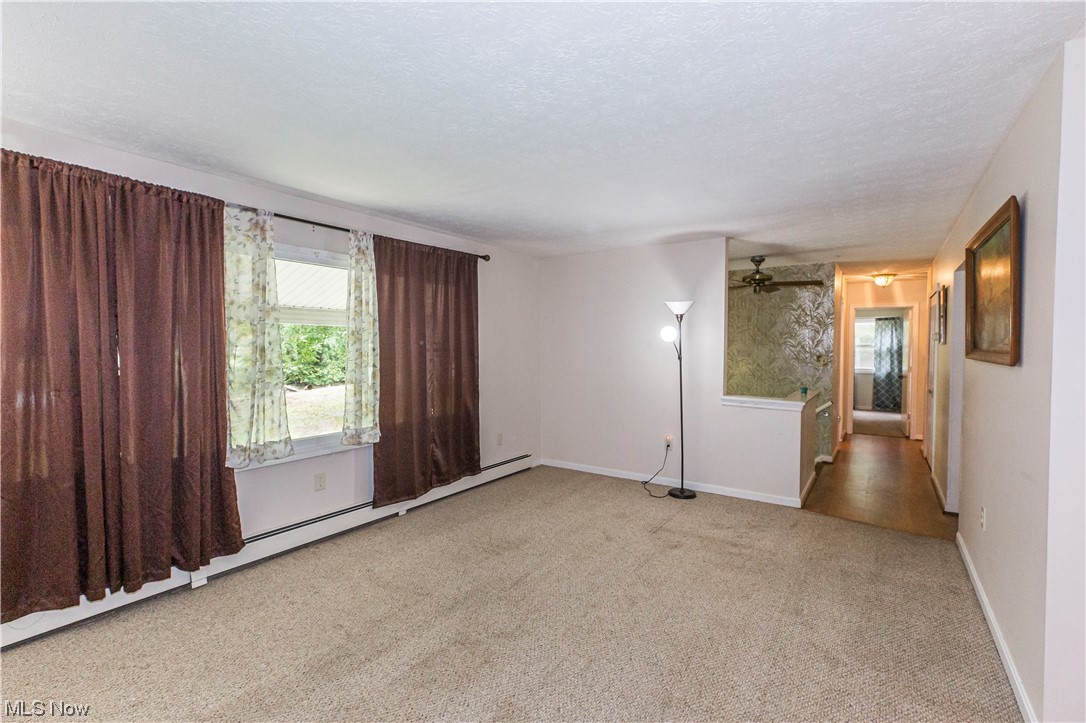 3077 Luli Road Mogadore, OH 44260 - Photo 7 of 34 Carpeted empty room with ceiling fan and a textured ceiling
