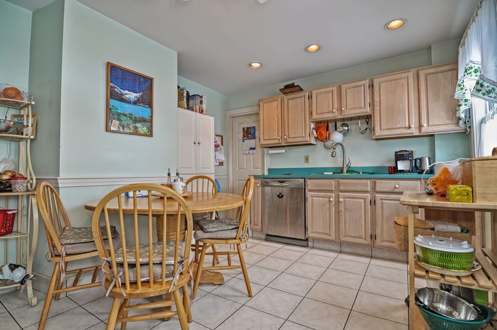 40-42 Mapleton Street Boston, MA 02135 - Photo 11 of 17 a kitchen with stainless steel appliances granite countertop a table chairs sink and cabinets