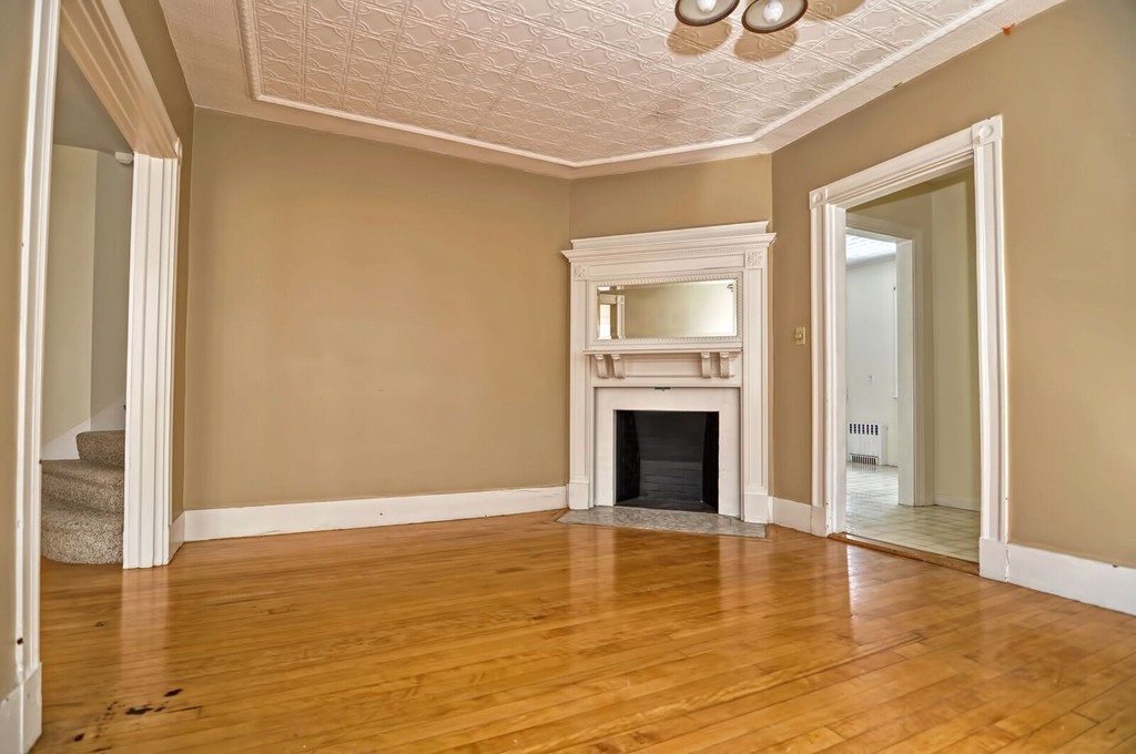 40-42 Mapleton Street Boston, MA 02135 - Photo 5 of 17 a view of empty room with wooden floor and fireplace