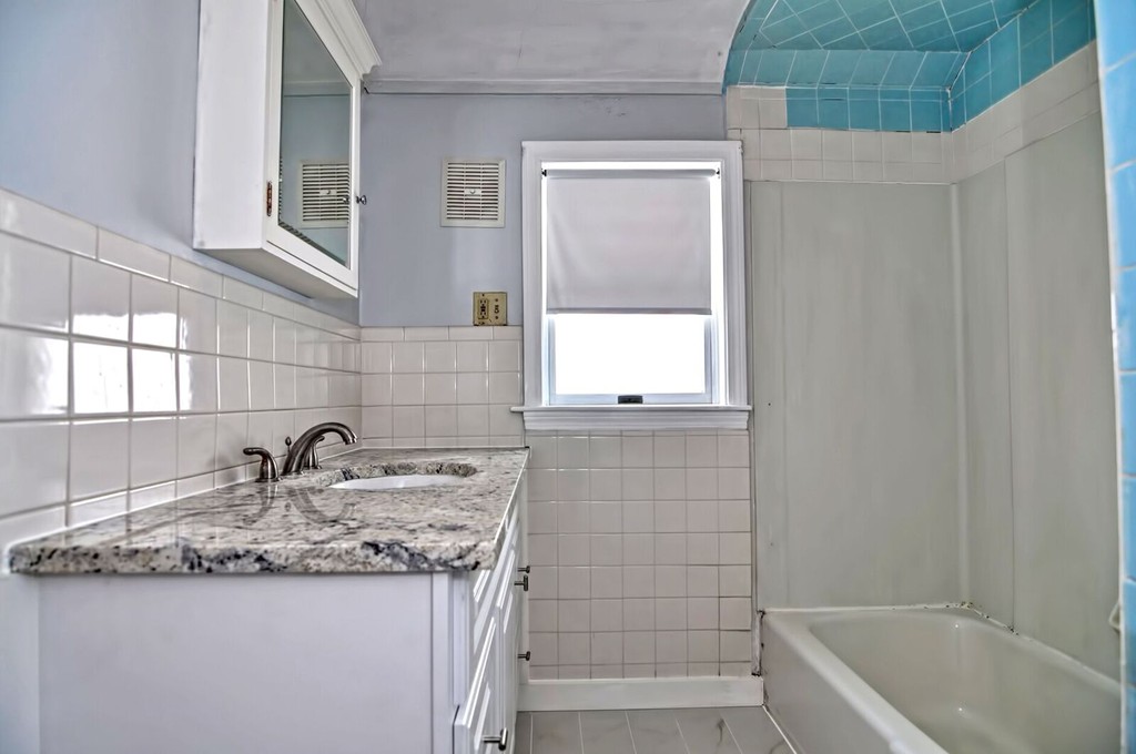 40-42 Mapleton Street Boston, MA 02135 - Photo 8 of 17 a bathroom with a granite countertop sink and a bathtub