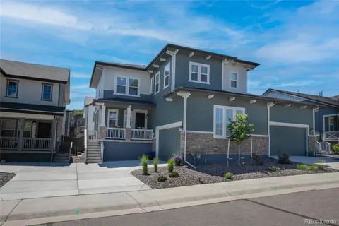 a front view of a house with garage and plants