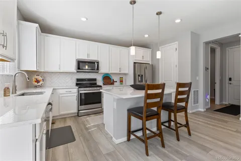 a kitchen with a table chairs refrigerator and microwave