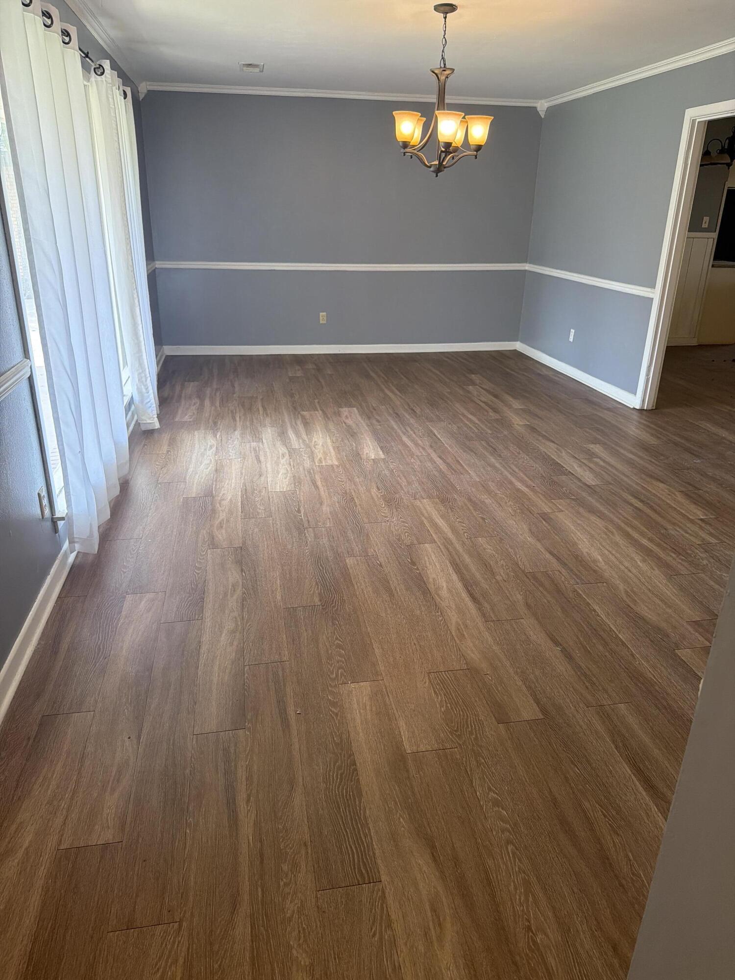 3814 27th Street Lubbock, TX 79410 - Photo 3 of 24 wooden floor in an empty room with a window