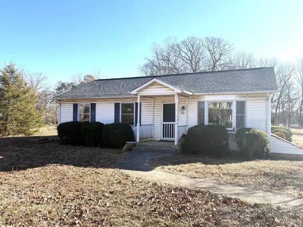 a front view of a house with a yard covered in snow