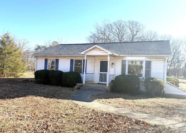 a front view of a house with a yard covered in snow