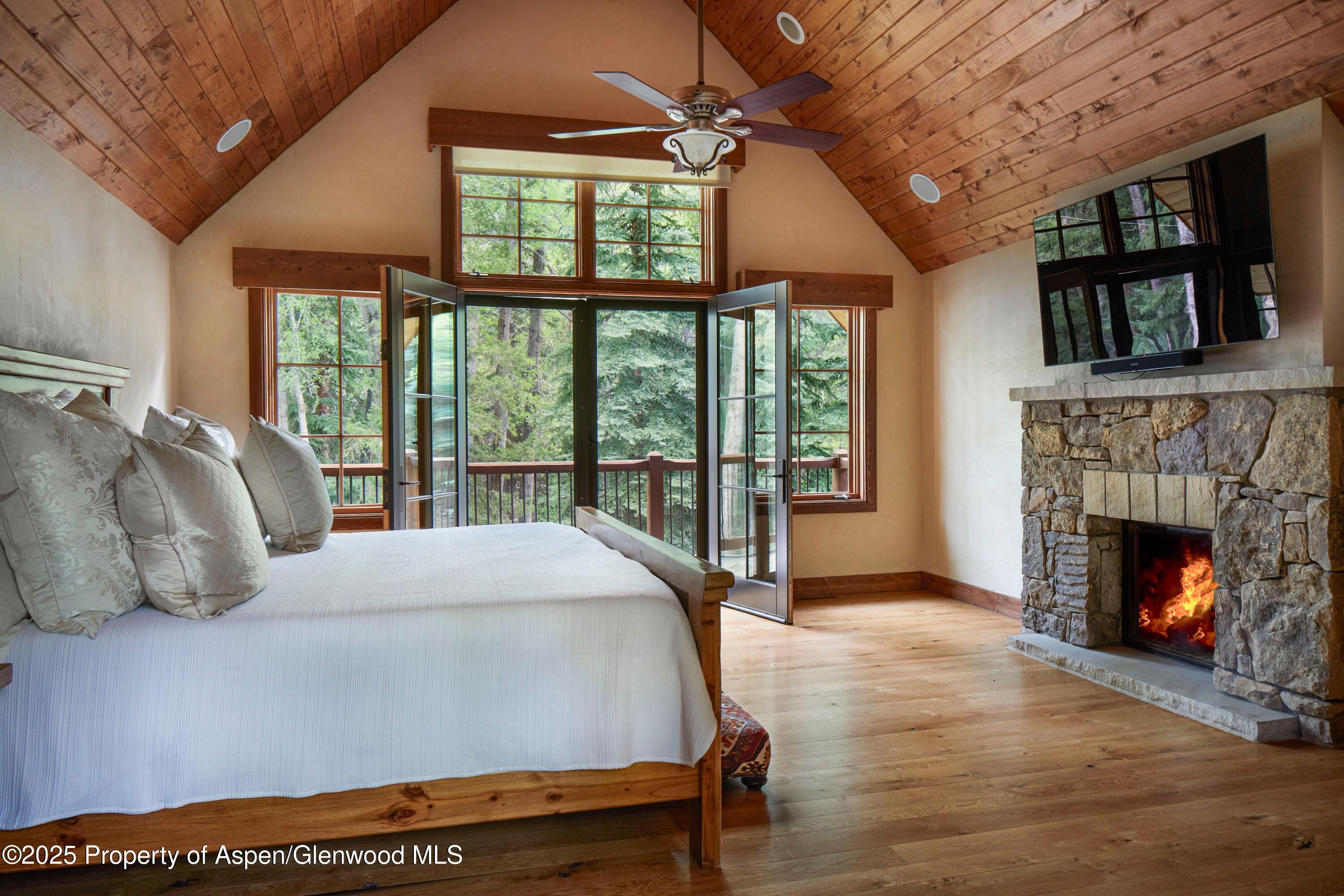 143 Conundrum Creek Road Aspen, CO 81611 - Photo 16 of 19 a bedroom with a bed and a fireplace