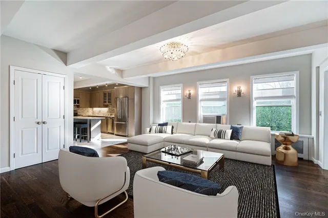 a living room with furniture wooden floor and a large window