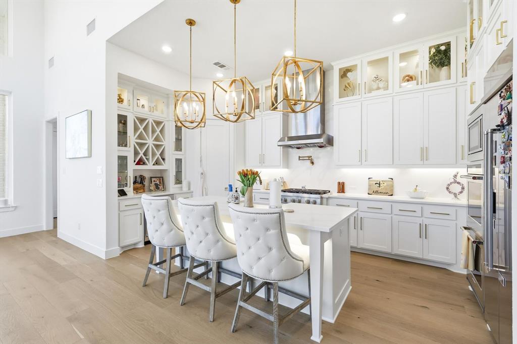 16194 Inca Dove Court Frisco, TX 75035 - Photo 13 of 40 Kitchen features a beautiful illuminated island, pot filler and upgraded Calacatta Gold quartz counters and full backsplash.