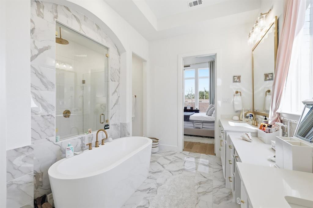 16194 Inca Dove Court Frisco, TX 75035 - Photo 19 of 40 Primary Bath featuring beautiful tile work on floors and in shower with rainhead fixture.