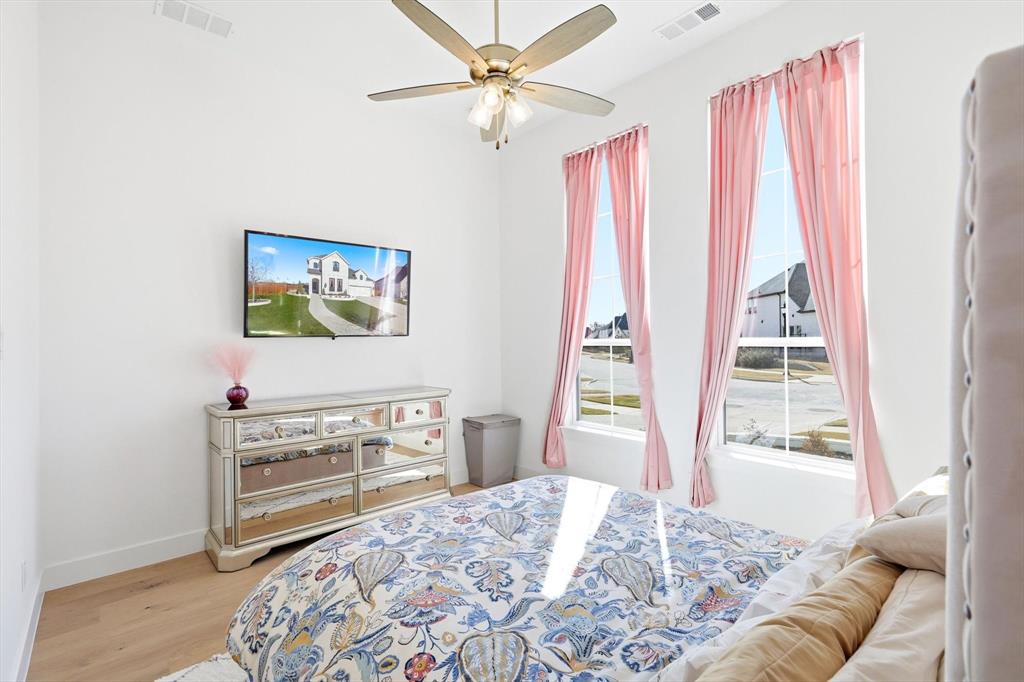 16194 Inca Dove Court Frisco, TX 75035 - Photo 21 of 40 Guest Bedroom 2 located on first floor is En Suite and features upgraded wood flooring and ceiling fan.