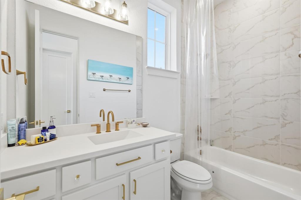 16194 Inca Dove Court Frisco, TX 75035 - Photo 22 of 40 Full Guest Bath featuring shower / tub combo with vanity and gold detailing everywhere.