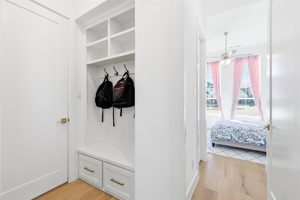 16194 Inca Dove Court Frisco, TX 75035 - Photo 24 of 40 Mud Room featuring mud bench with storage below and upgraded wood flooring.