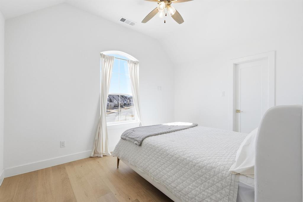 16194 Inca Dove Court Frisco, TX 75035 - Photo 30 of 40 Bedroom 3 at front of home with upgraded wood floors, tall ceilings, ceiling fan and large walk-in closet.