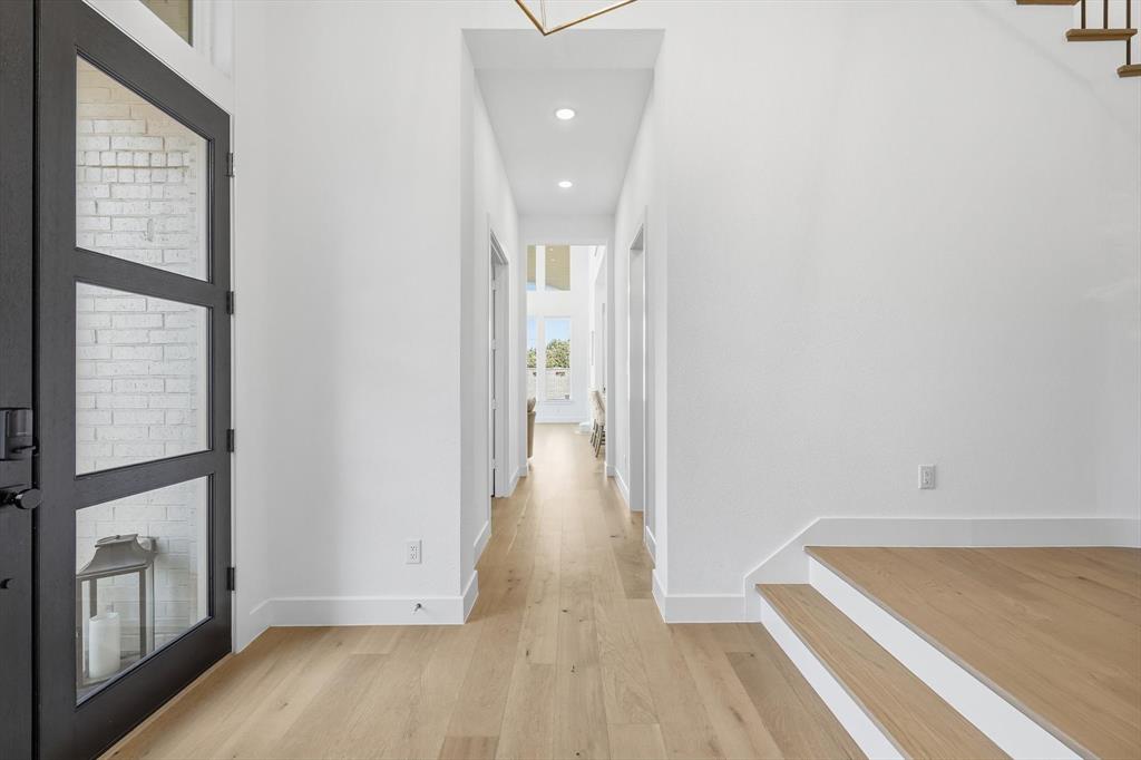 16194 Inca Dove Court Frisco, TX 75035 - Photo 4 of 40 Dramatic Foyer featuring upgraded wood flooring and decorative lighting.
