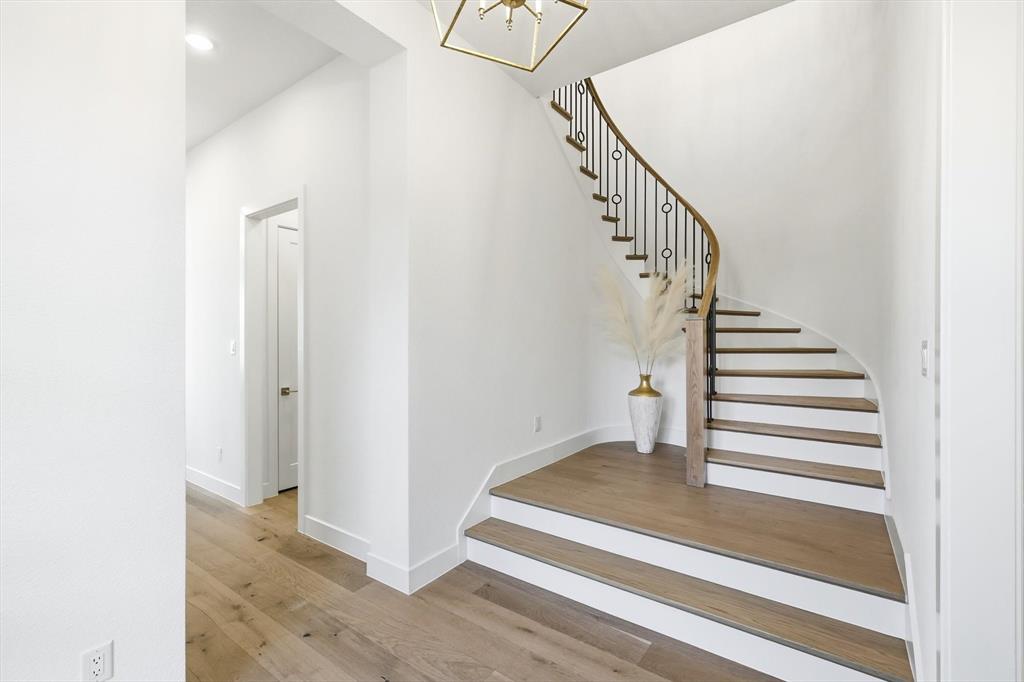 16194 Inca Dove Court Frisco, TX 75035 - Photo 5 of 40 Stairs with hardwood floors, painted risers and a chandelier