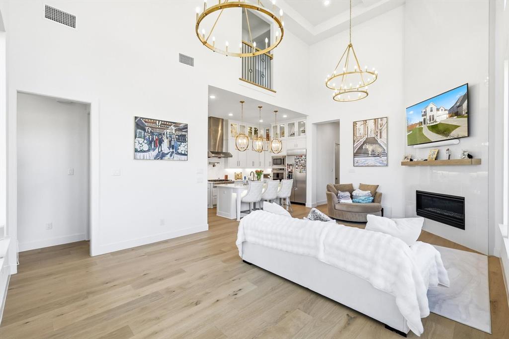 16194 Inca Dove Court Frisco, TX 75035 - Photo 8 of 40 Family Room with chandeliers, a full tiled fireplace, and upgraded wood flooring. Note that there is room for Dining in this area should Formal Dining be utilized as Home Office.