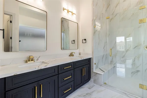 a bathroom with a double vanity sink mirror double and shower