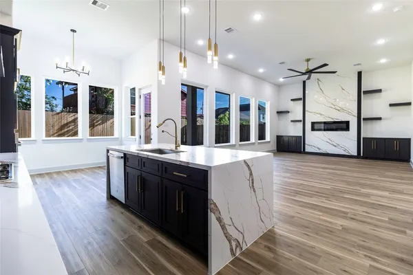 a kitchen with stainless steel appliances granite countertop a sink a counter space and a wooden floors