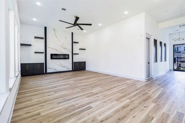 a view of a kitchen with wooden floor and a ceiling fan