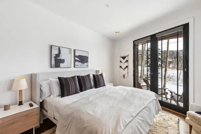 a bedroom with a large bed and a lamp next to a window