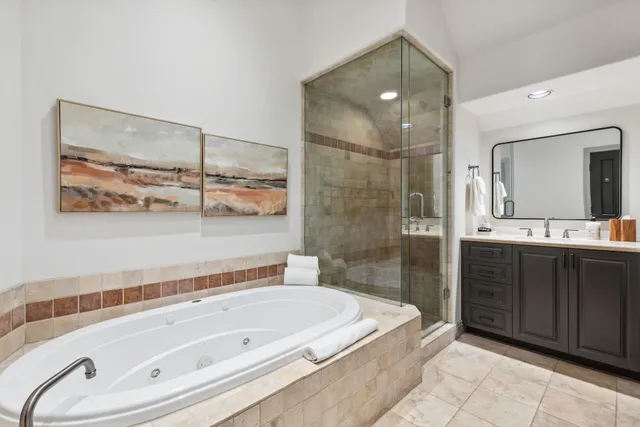 a bathroom with a tub a sink and mirror