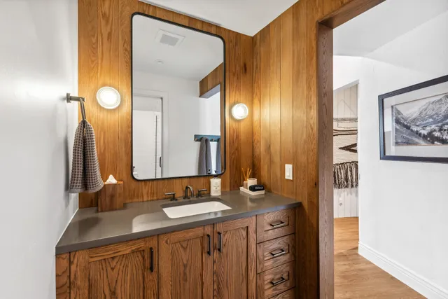 a bathroom with a granite countertop sink and a mirror