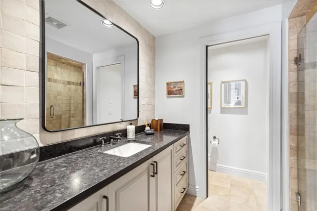 a bathroom with a granite countertop sink and a mirror