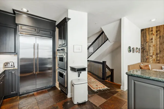 a kitchen with granite countertop a refrigerator and a sink