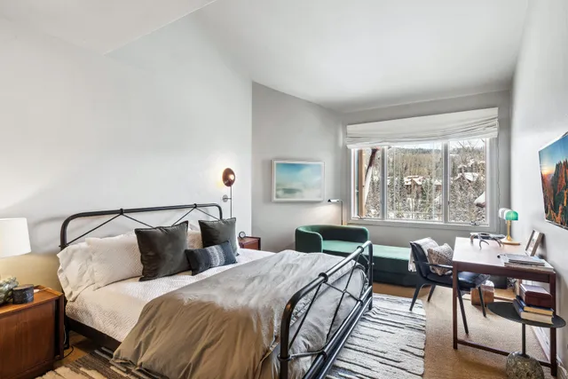 a bedroom with a bed and a large window