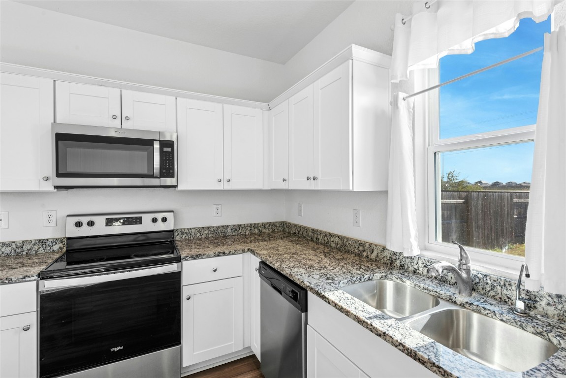566 Delta Crest Maxwell, TX 78656 - Photo 9 of 27 a kitchen with granite countertop white cabinets white stainless steel appliances and a sink