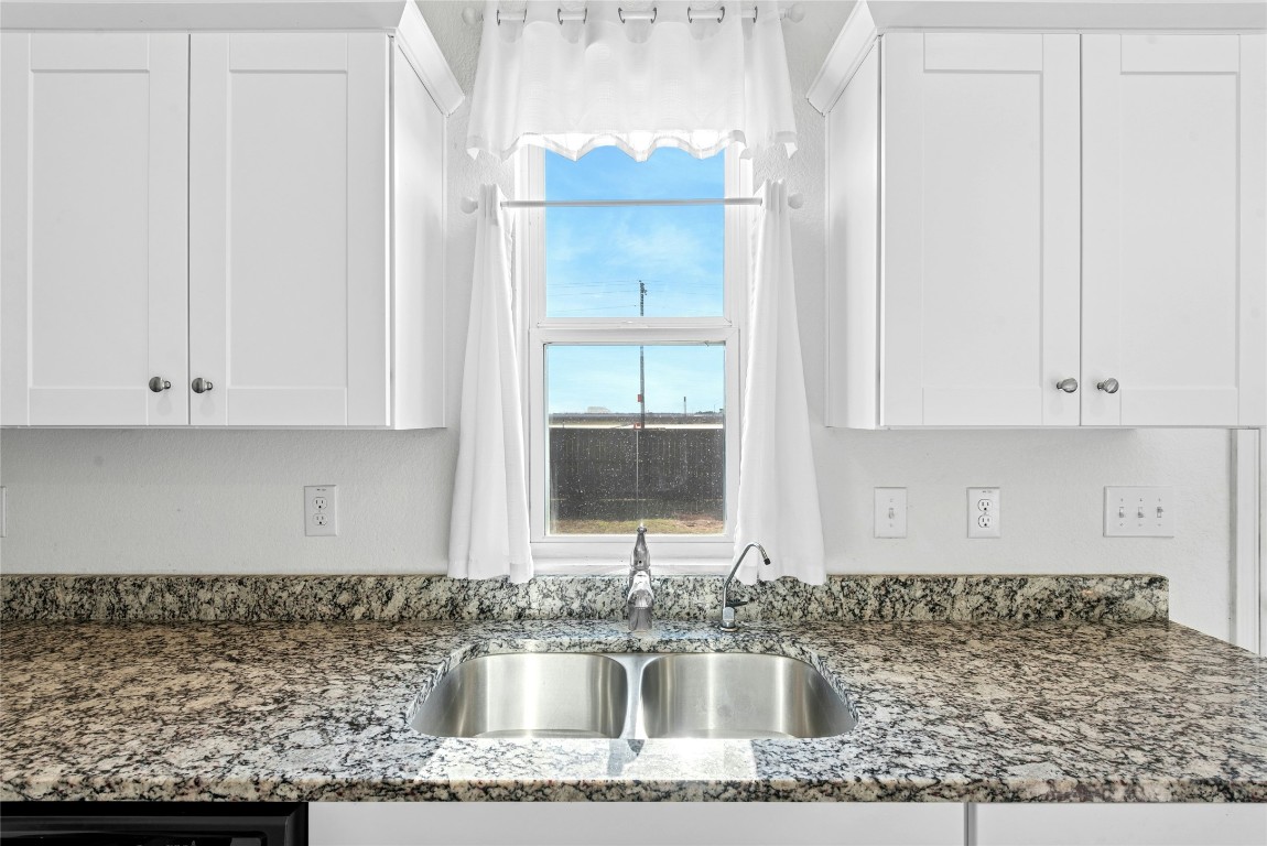 566 Delta Crest Maxwell, TX 78656 - Photo 10 of 27 a kitchen with granite countertop a sink and a stove