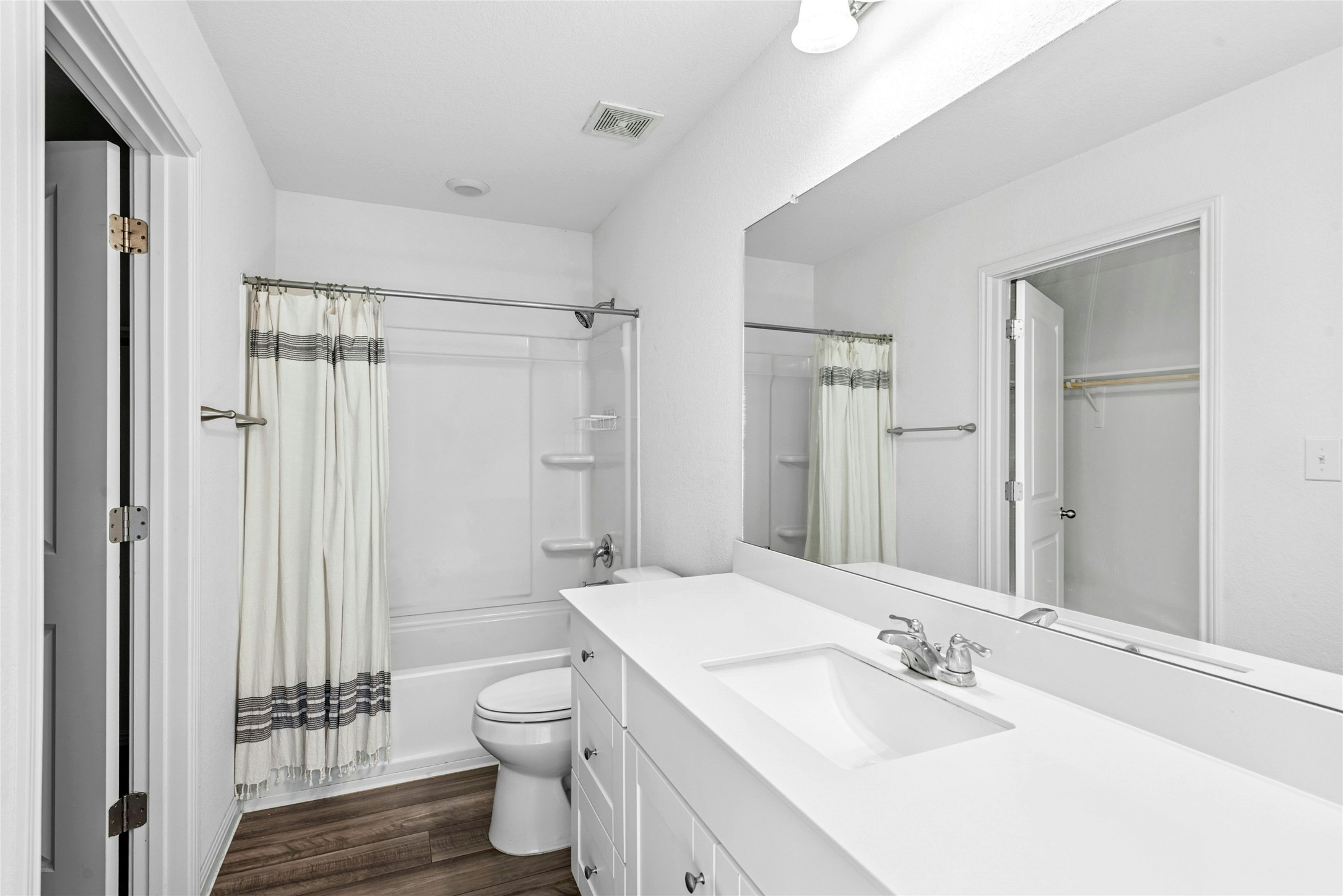 566 Delta Crest Maxwell, TX 78656 - Photo 14 of 27 Bathroom featuring shower / bath combo, vanity, dark wood finished floors, and a walk in closet