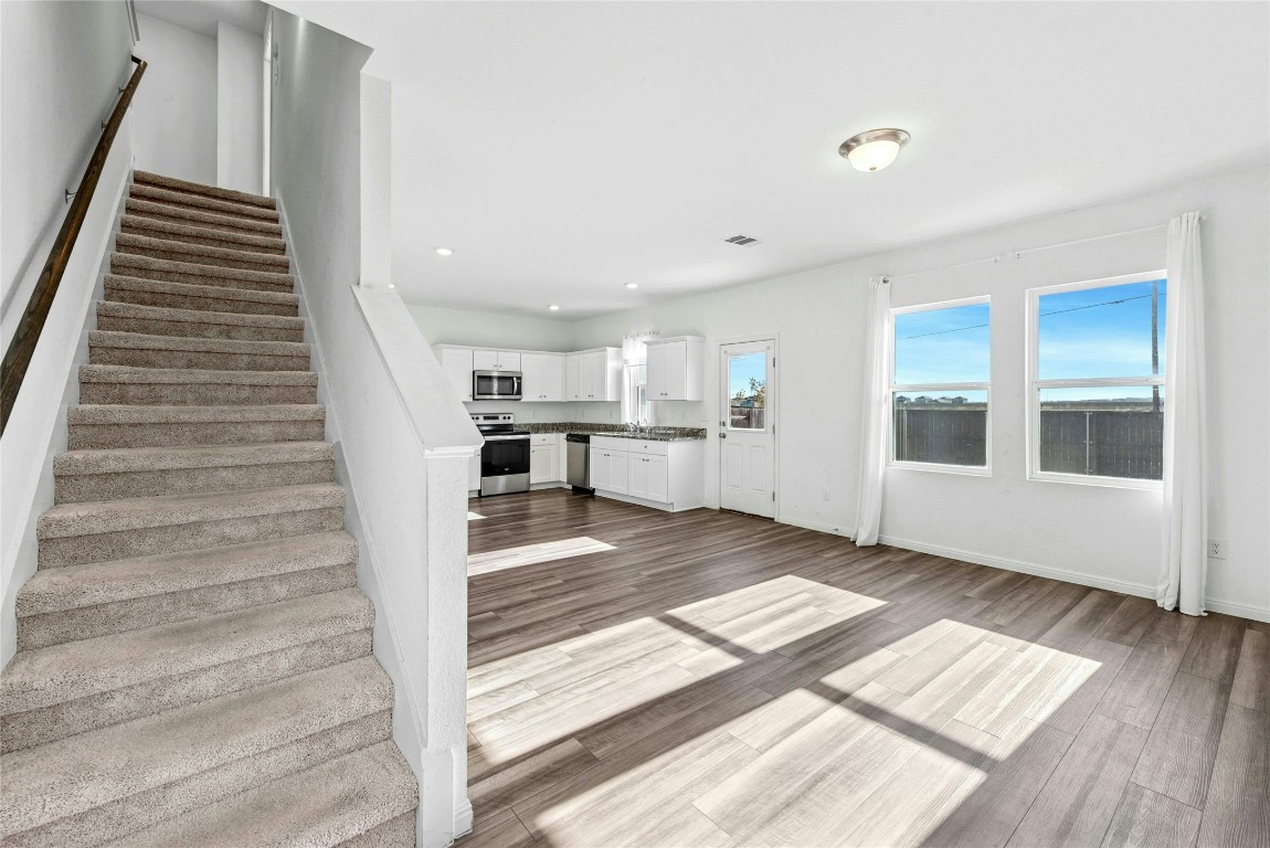 566 Delta Crest Maxwell, TX 78656 - Photo 25 of 27 a view of an empty room with wooden floor and stairs
