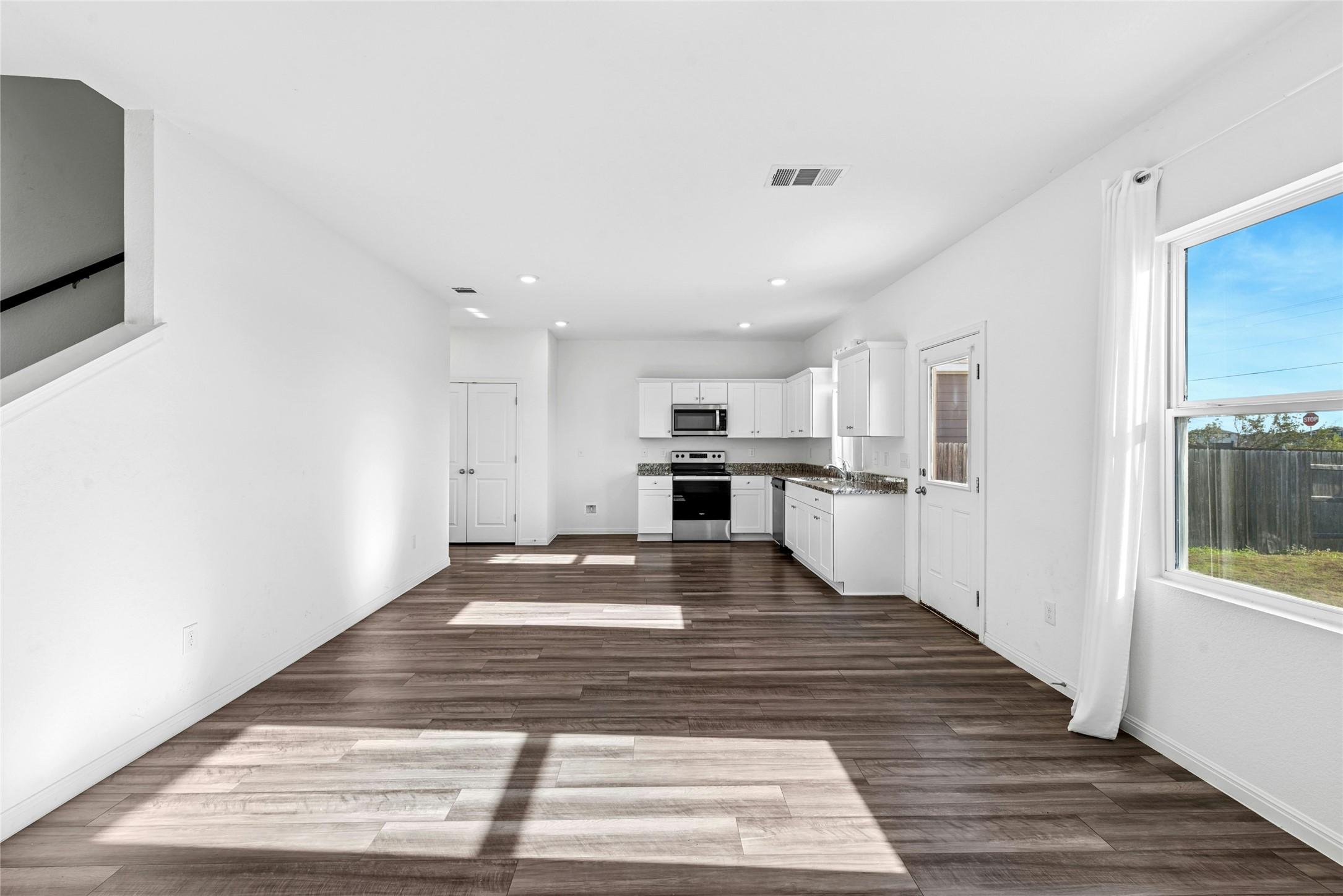 566 Delta Crest Maxwell, TX 78656 - Photo 26 of 27 Kitchen with white cabinets, stainless steel appliances, dark wood-style floors, open floor plan, and recessed lighting