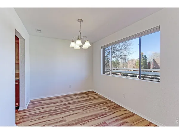 a kitchen with white cabinets and refrigerator